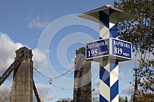 Milepost with names of the cities in Russian and distance in kilometers