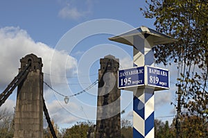 Milepost with names of the cities in Russian and distance in kilometers