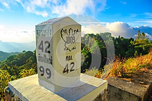 Milestone at the roadside with mountain landscape