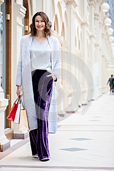 Miling beautiful middle aged woman in knitted bright summer coat