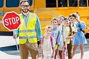 miling traffic guard with scholars looking at camera in front of