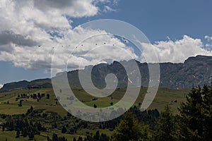 Military airborne troops being airdropped over Seiser Alm in the Dolomites, Northern Italy