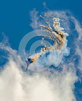 Military aircraft fighter SU-27 nose-dive, performs the maneuver with the ejection of heat missiles