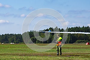 Military armed man wearing camouflage look at take off plane SAAB 105 Sk 60 on airshow at Ronneby flygdag F-17