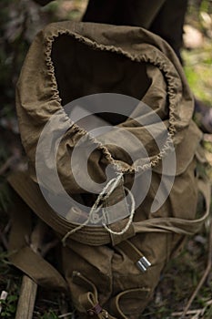 Military backpack stands on the ground uncovered