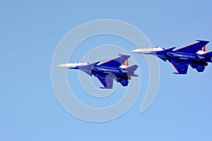 Aviation pilots demonstrate high aerobatics on fighters. Aircraft bombers in the blue sky. Military aircraft in the sky