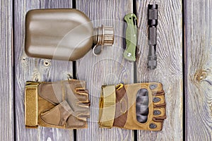 Military bottle, pair of gloves, pocketknife and torch.