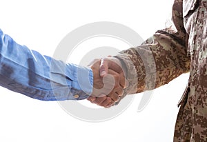 Military and civilian shaking hands standing on white background