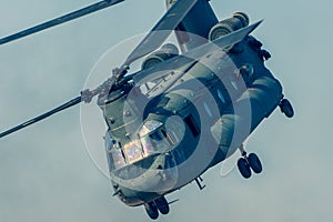 Military combat and war with Chinook helicopter close up flying through the chaos. Military concept of power, force, strength, air