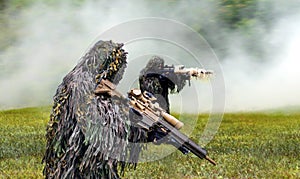 Commando dressed in ghillie camouflage during  combat warfare photo