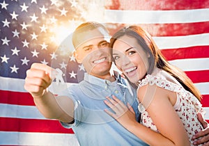 Military Couple Holding House Keys In Front of American Flag