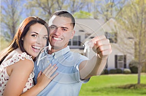 Military Couple with House Keys In Front of New Home photo