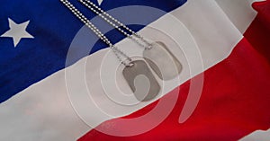 Military dog tags over american flag background with copy space