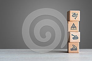Military defence icons on wood bricks stacked on a table with grey background photo