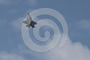 Military F35 fighter jet flying. Blue sky with clouds. Lockheed Martin F-35B `Lightning` II