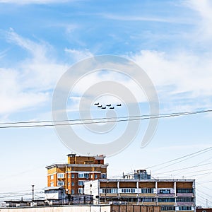 Military fighter aircrafts flight over urban house