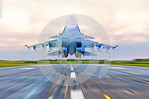 Military fighter jet flies at high speed over the taxiway at the airport.