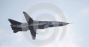 Military fighter plane with variable sweep wing on sky background.