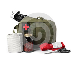 Military first aid kit, tourniquet, pills and tools on white background