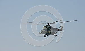 The military helicopter against the blue sky