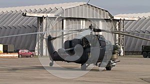 Military helicopter on background of hangars