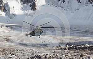 Military helicopter landing on ice of mountain galcier in Emergency situation