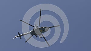 Military helicopter maneuvers in the blue sky