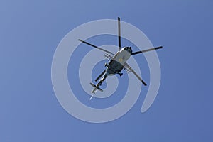 Military helicopter maneuvers in the blue sky