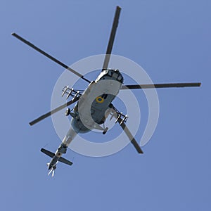 Military helicopter maneuvers in the blue sky