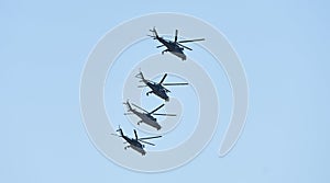 Military helicopters maneuvers in the blue sky