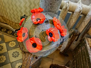 Military helmet painted with poppies in peace symbols.