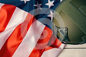 Military helmets and American flag on background