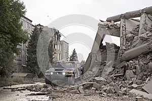 Military Humvee standing in the middle of collapsed concrete buildings