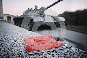 Military ID of the Russia on a stone on background of a tank. Mobilization in Russia . Russian inscription on the