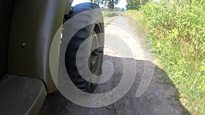 Military jeep  car driving on dirt road, close up of wheel