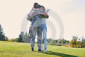 Military man father hugs daugther and wife.