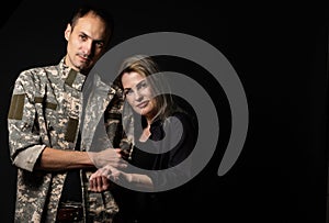 military man and his wife on a black background