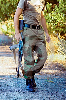 A military man holding an assault rifle