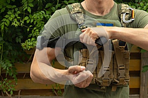 A military man holds a medical tourniquet in his hands to stop blood in first aid and prevent bleeding.