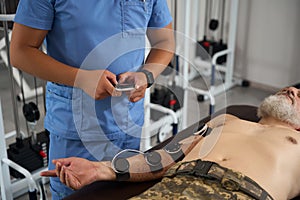 Military man in a rehabilitation center undergoing a physiotherapeutic procedure