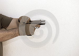 Military man wearing gloves and reloading his handgun photo