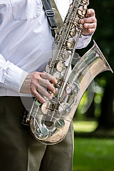 Military orchestra musician playing saxophone on music festival