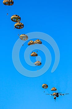 Military parachutist paratroopers jumping out of an air force airplane photo