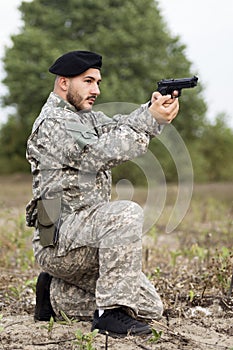 Military person holding pistol