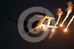 Military plane firing flares during a  night flight
