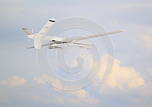 military RC military drone flies against the backdrop of blue peaceful sky with white clouds