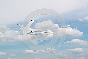 military RC military drone flies against the backdrop of blue peaceful sky with white clouds