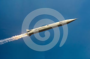 A military rocket flies against the blue sky