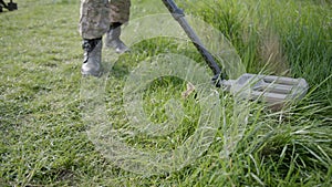 Military sapper with a metal detector in the field