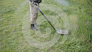 Military sapper with a metal detector in the field